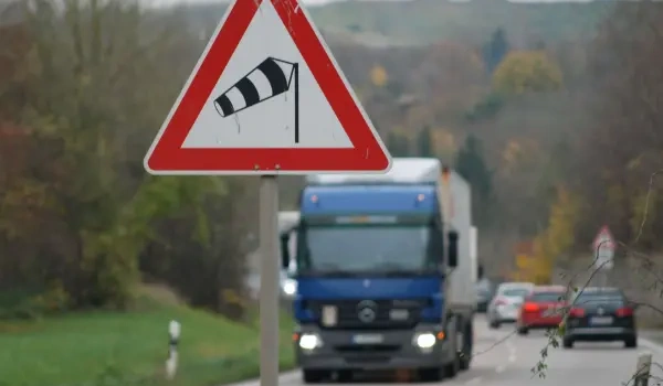 What should you do when encountering crosswinds on the highway?